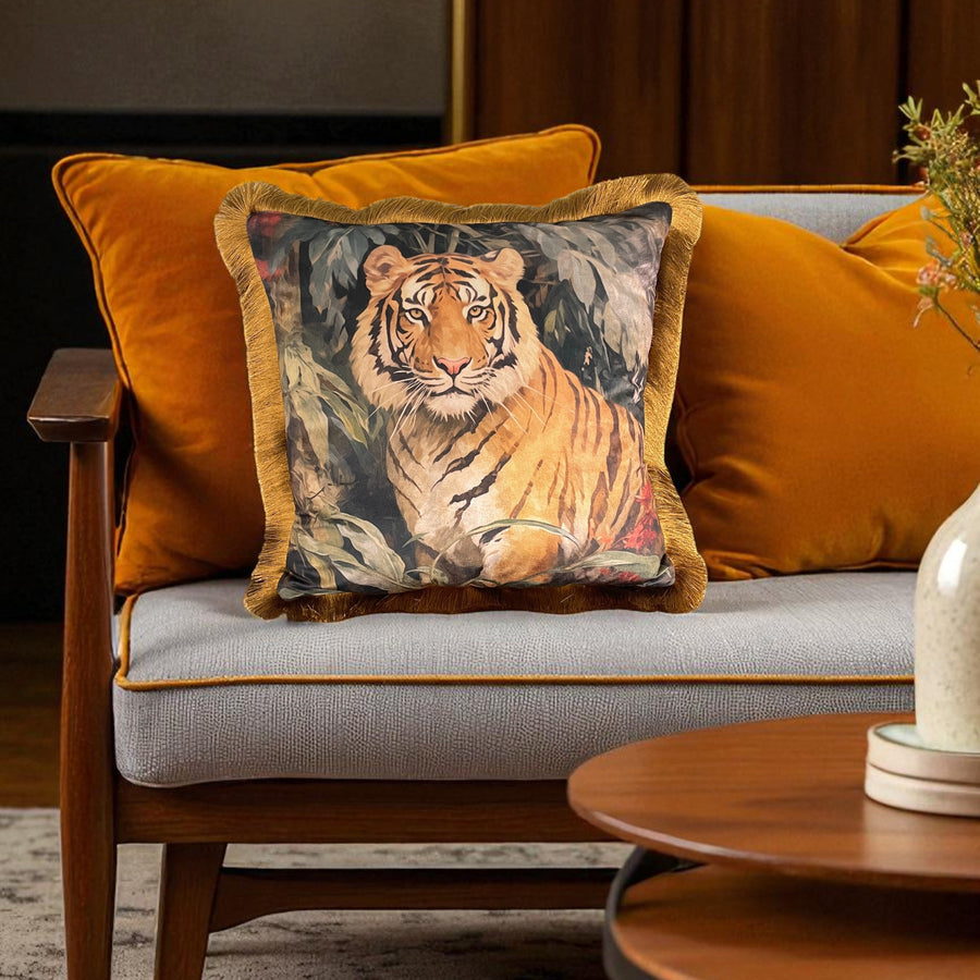 Decorative pillow with a tiger design on a sofa with orange cushions.